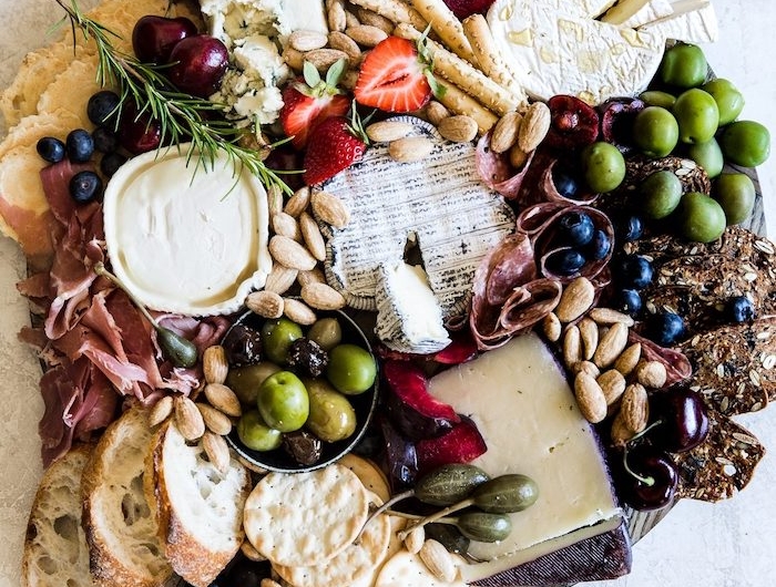 plateau charcuterie avec des crquelins et des olives differentes types de fromage avec des olives