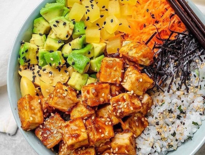 poke bowl vegetarien à base de tofu mariné riz au sésame mangue carrote rapée mangue dans un bol
