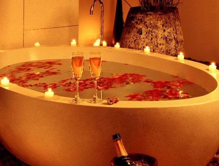 saint valentin celibataire un bain avec)baignoire décoré des pétales de rose une bouteille dechampagne avec deux verres