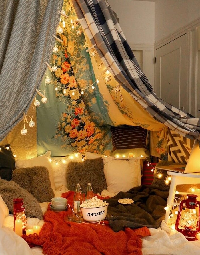saint valentin célibataire a la maison avec des popcorns des lantenres et des laùpes dans une tente de linges