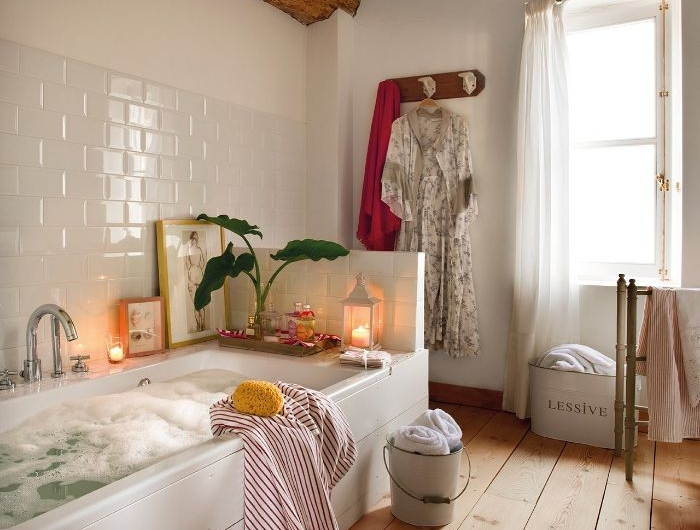 salle de bain blanche avec sol bois plancher vintage rideaux transparents poutre apparente bois lanterne bougie