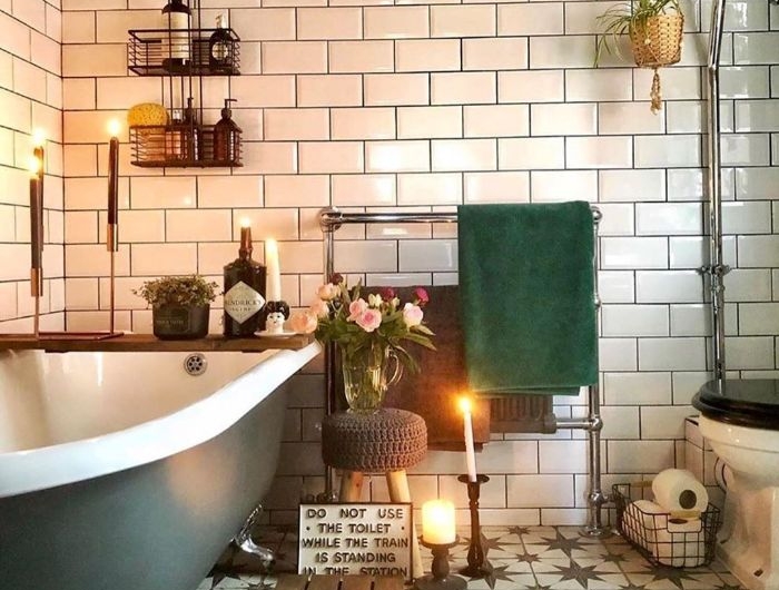 salle de bain cocooning avec carrelage metro blanc baignoire ancienne grise bougies décoratives étagères industrielles
