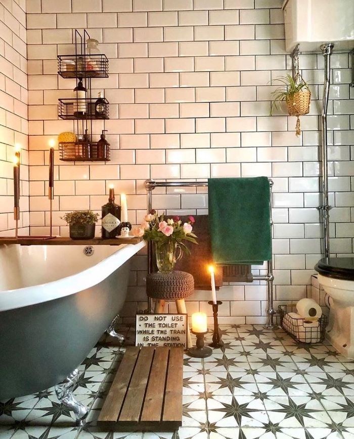 salle de bain cocooning avec carrelage metro blanc baignoire ancienne grise bougies décoratives étagères industrielles