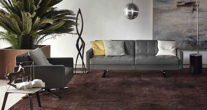 tendance chambre 2021 un tapis en couleur bordeaux canapé gris en cuir et une balle disco pendante du plafond