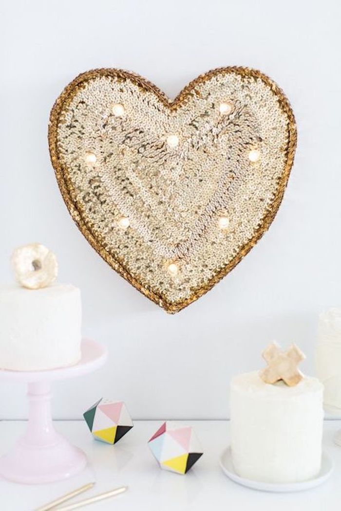 un coeur décoratif en pailletes sur un mur blanc décoration saint valentin