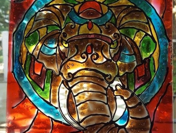 un dessin boudhiste avec un elephant dessine sur un vitre atelier de pienture su verre
