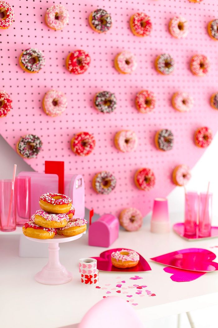 un paneau avec des beignets au chocolat collés des gobelets roses sur une table st valentin originale