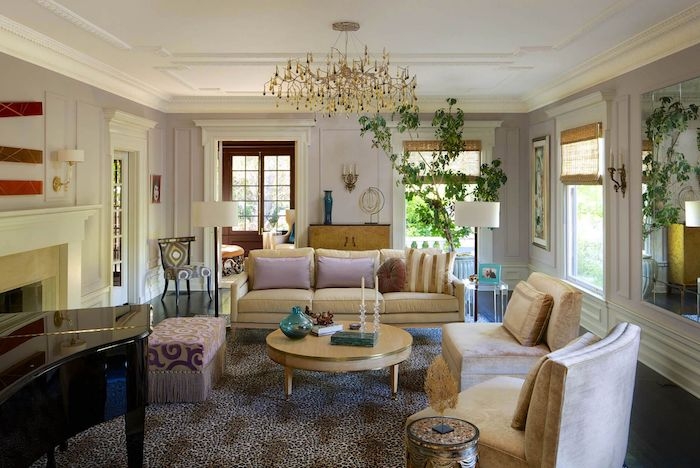un salon maximaliste avec un tapis animalier une grande plante verte et des canapes beiges avec des coussins roses