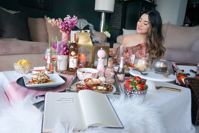 une femme assise devant une table avec des repas abondantes saint valentin celibataire