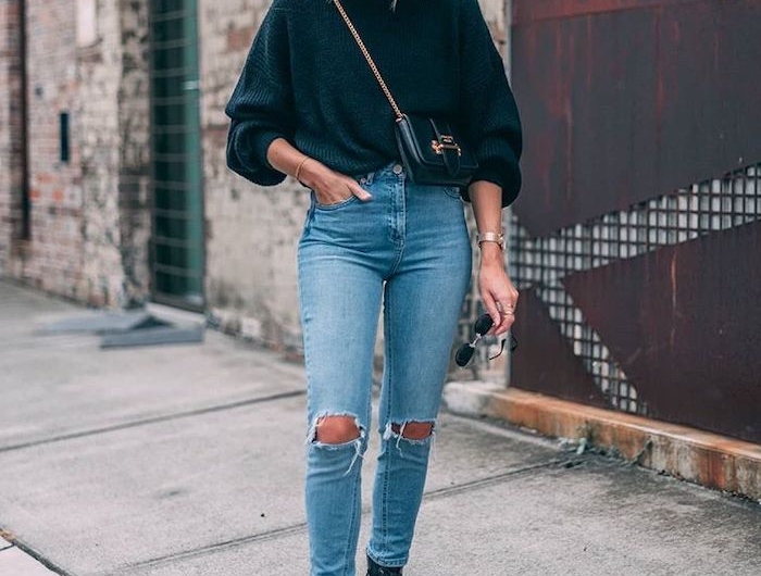 une femme avec jean déchire pull noir et des bottines style doc martens