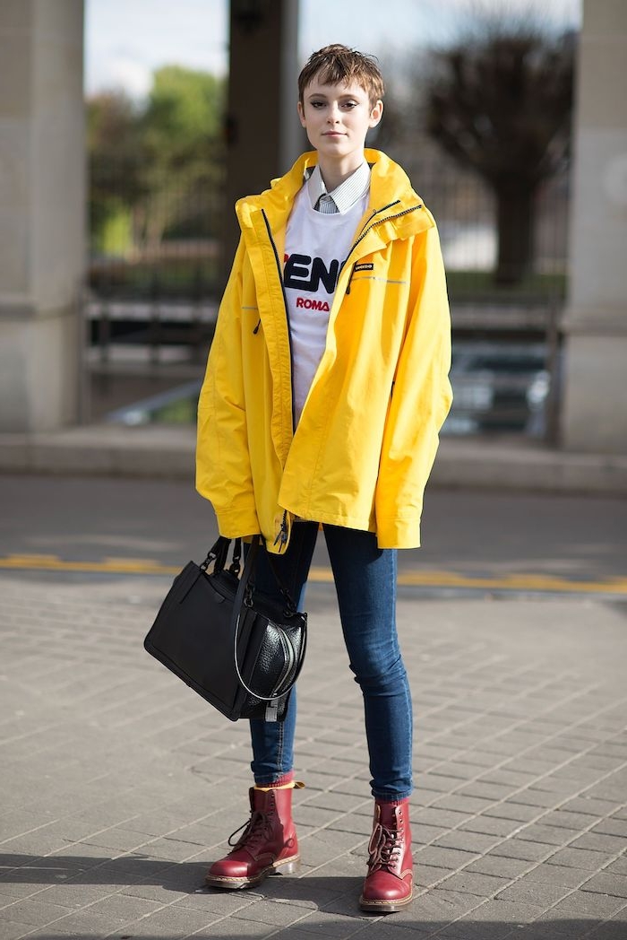 une fillen imperméable jaune des bottines rouges et jean bleu foncé