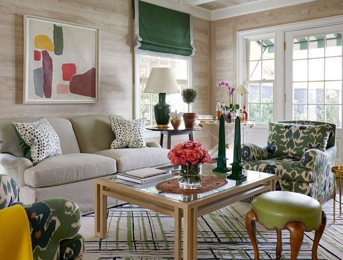 une salle de séjour avec des meubles et détails à motifs en couleurs verte olive et jaune une vase a fleurs roses sur une table en verre