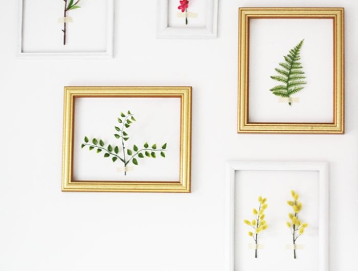 deco murale tendance pour printemps salon cadres en blanc et or avec des branches de fleurs à l intérieur mur blanc décoré