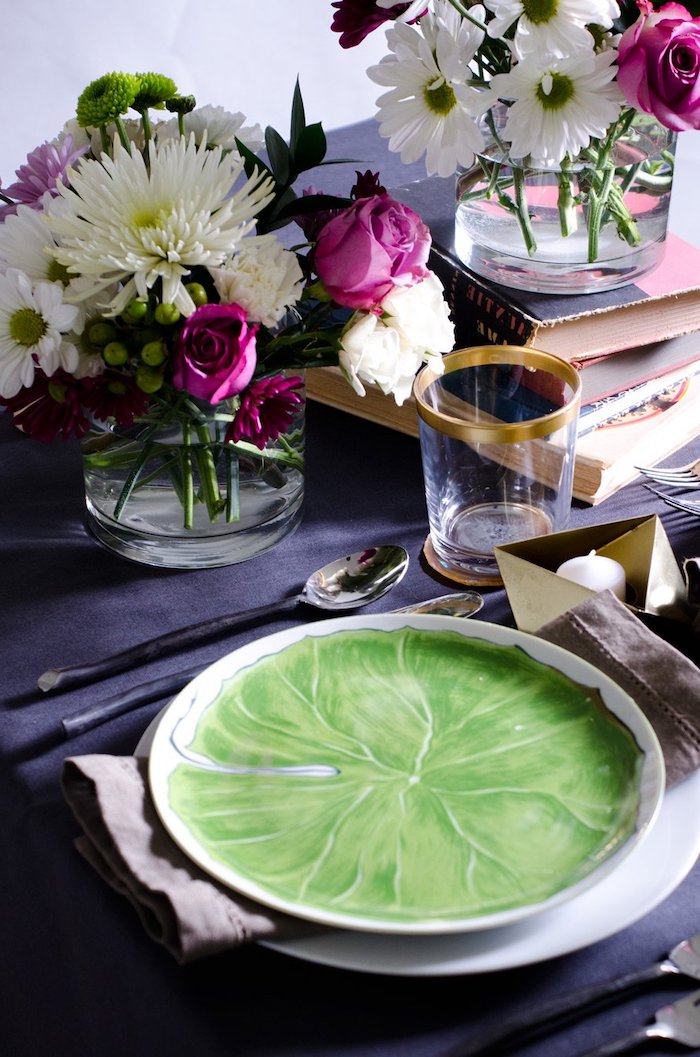déco amour avec des bouquets sur une nappe bleue marine et une assiette en porcelaine peinte en vert