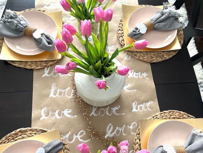 déco table sain valentin avec un chemin de table en papier dessiné et des tulipes roses