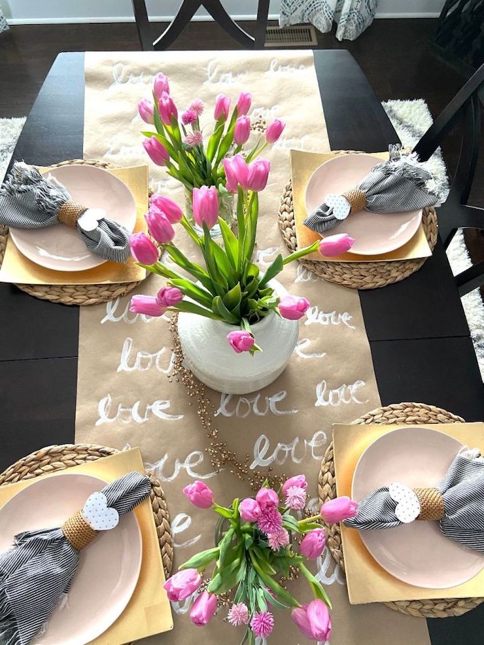 déco table sain valentin avec un chemin de table en papier dessiné et des tulipes roses