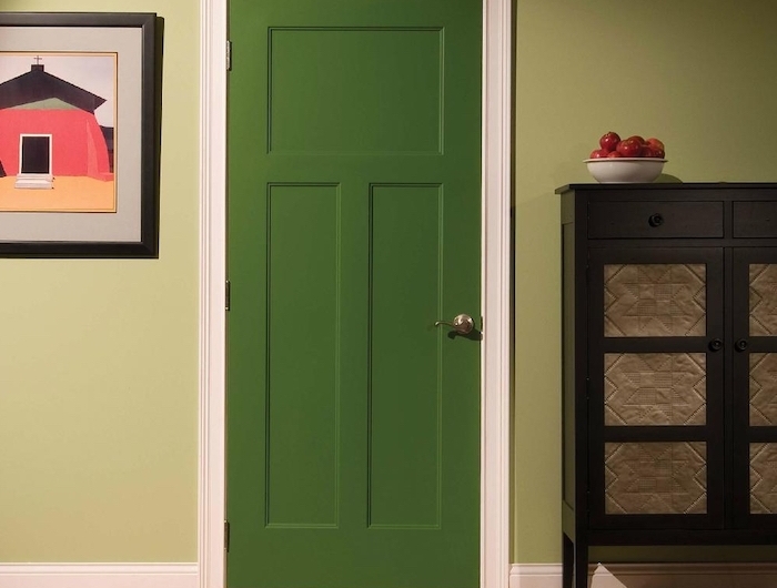 décoration couloiur d entré avec une porte verte dans un cadre blanc entre un tableu et un commode en bois