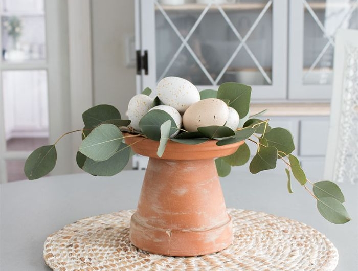 diy paques activité manuelle printemps deco table en pot de fleur renversé et blanchi et des oeufs de paques couleurs pales