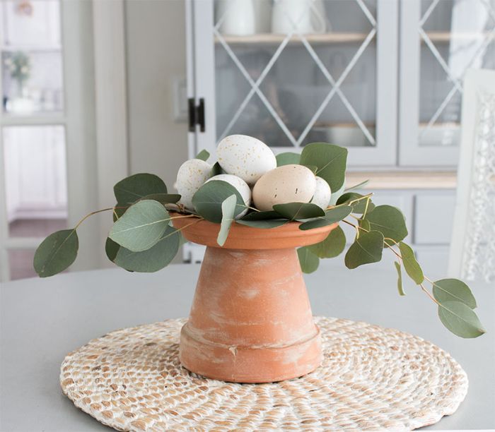 diy paques activité manuelle printemps deco table en pot de fleur renversé et blanchi et des oeufs de paques couleurs pales