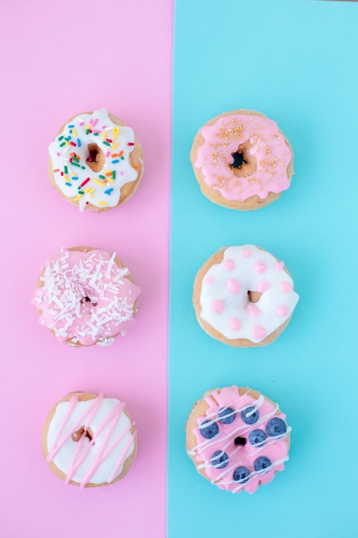 fond d écran aesthetic en rose et bleu pastel avec des beignets donuts colorés appétissants