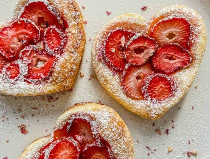 gâteau à la fraise en forme de coeur tartalette pâte feuilletée fraises et sucre glace dans assiette