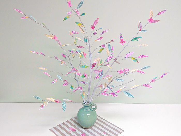 idée déco branche d arbre blanchies de peinture avec des fleurs et feuilles en papier scrapbooking à motifs colorés
