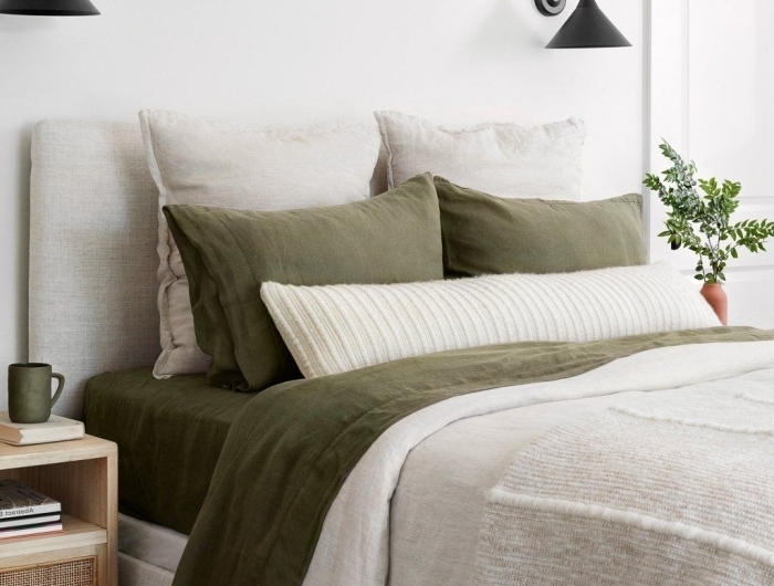 linge de lit déco de chambre kaki accents taie oreillers couverture vert foncé tasse de café meuble chevet bois rotin