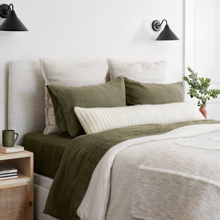 linge de lit déco de chambre kaki accents taie oreillers couverture vert foncé tasse de café meuble chevet bois rotin