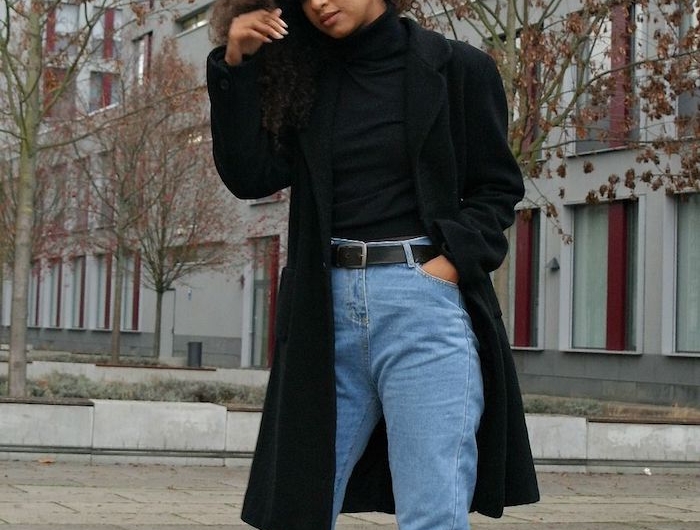 look jean mom hiver avec un manteau longueur aux genoux des bottines noires et un pull a colle haute