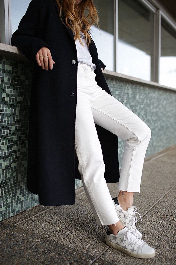 look jean mom hiver en couleur blanc combiné avec un manteau longue en laine et des baskets aux motifs etoiles