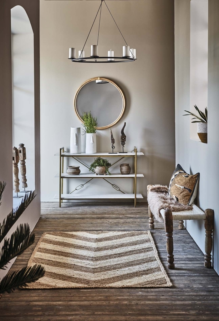meubles bois et or banquette bois tapis beige et blanc plante verte peinture couloir étroit miroir rond
