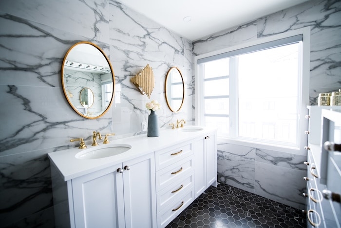 miroir rond accroché au mur salle de bain avec encadrement laiton idee deco salle de bain marbre et laiton elegante