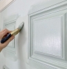 peindre une porte a l aide d un pinceau et de la peinture blanche