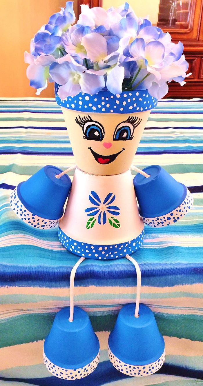 personnage ne pot de fleur une idéee de décoration en couleur bleu et blanc avec des fleures fausses sur la tete