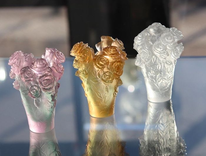 petites vases de la cristallerie daum avec des ornements en roses sur une table en verre