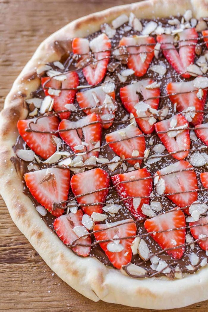 pizza maison sucrée à base de nutella et fraise avec des amandes hachés faire un dessert original au chocolat