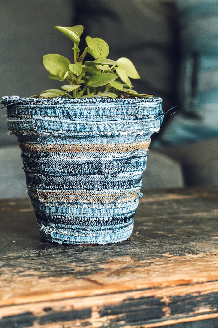 pot de fleur riginal décoré avec des tissu d un jean vieux posé sur une table vintage