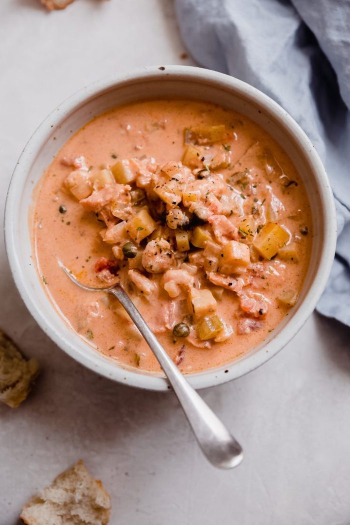 recette a base de saumon une soupe avec de mais servie dans un bol et des tranches de pain