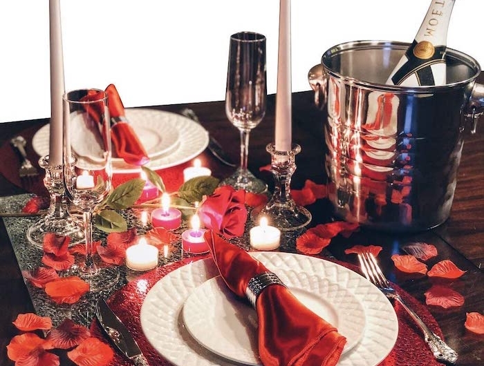 repas romantique une idée de mettre la table avec des pétales de rose et des bousies des serviettes rouges dans deux assiettes