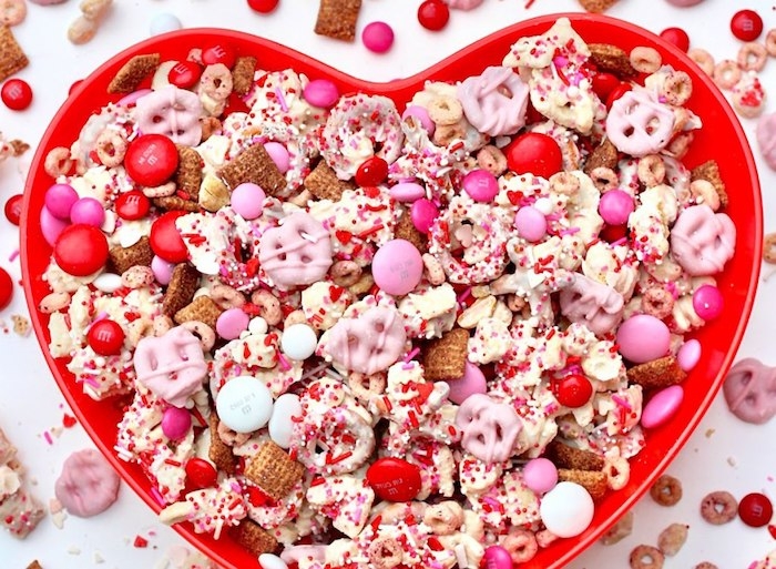 un bol en forme de coeur rempli des bonbons et des gourmandies pour saint valentin