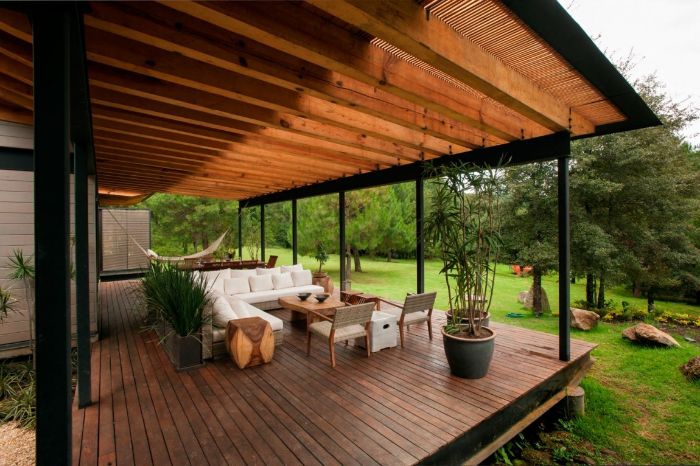 amenagement terrasse bois avec salon de terrasse avec table chaises et canapé couverture pergola et plantes exotiques