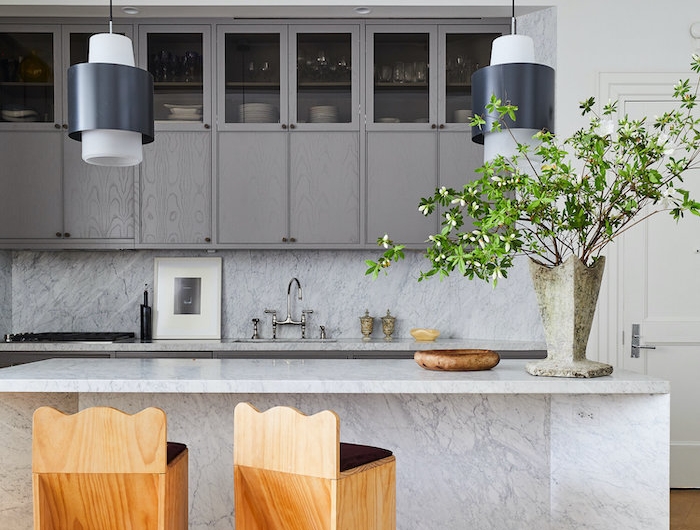 aménager petite cuisine fermée avec un bar en marbre et deux chaises en bois modernes