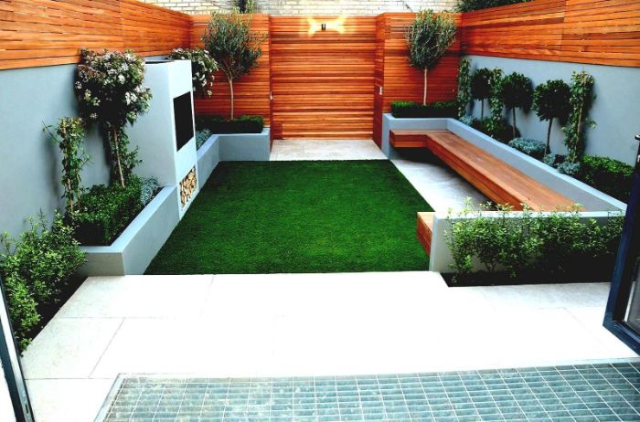 aménagement de terrasse extérieure avec gazon vert banc de bois mur cloture de bois bordure de buis et arbres