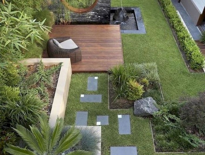 bassin d eau pelouse verte dalles de beton terrasse buis arbres rochers idee deco exterieur zen