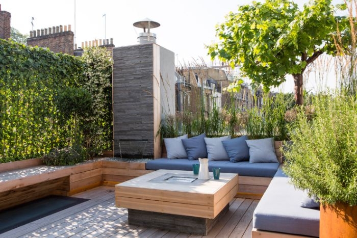 brise vue de jardin mur végétal canapé d angle avec coussin d assise grise table bois plantes vertes d exterieur