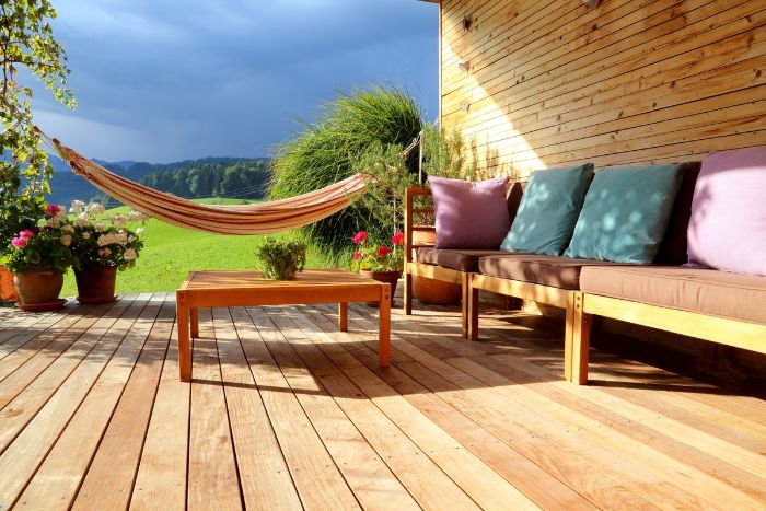 canapé de bois couvert de housses d assise et de coussins coloréstable basse bois amenagement terrasse devant maison