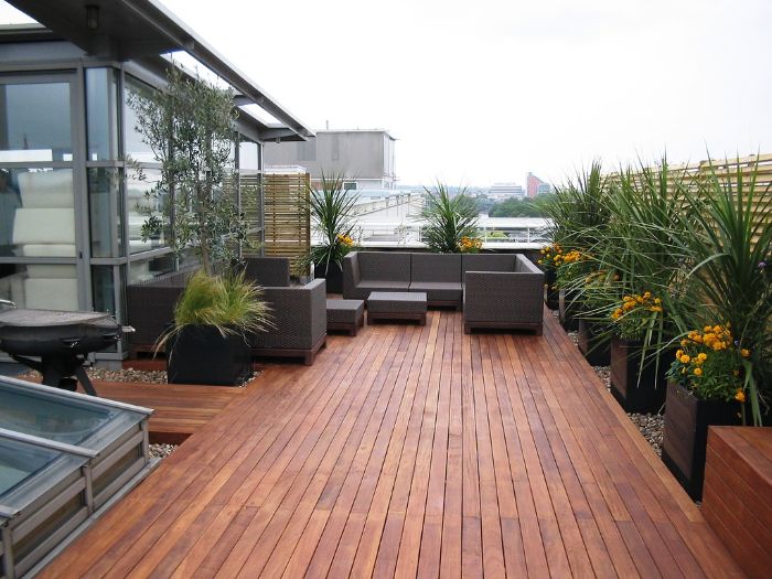 canapé et table exterieur en resine sur terrasse de bois avec des bacs à flurs bois et plantes à l intérieur terrasse de toit