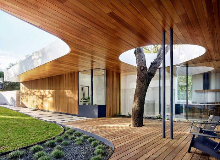 chaise longues sur terrasse bois couleur noire et arbre cailloux noirs pelouse idée maison moderne idee amenagement terrasse