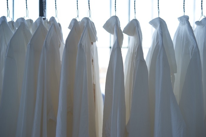chemises blanches suspendu et rangés dans une armoire style minimaliste tenue chic femme