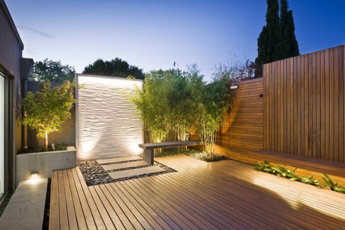 cloture de bois avec bambou dans un angle banc de bois galets terrasse deco exterieur maison éclairage nuit